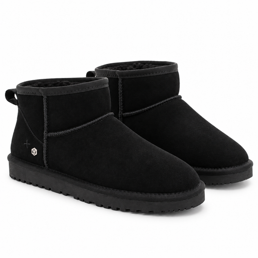 A pair of black suede ankle boots with black faux-leather trim and thick black soles, shown on a clean white background.