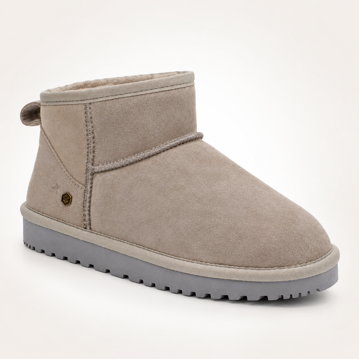 A single mid-calf suede boot in a light taupe-beige color with a gray sole, shown from a three-quarters angle on a clean white background.
